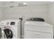 Bright laundry room featuring a modern, front-loading washer and dryer, plus convenient shelving above at 4240 Spring Ridge Dr, Cumming, GA 30028