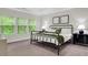 A well-lit bedroom featuring three windows and a modern bed frame at 4240 Spring Ridge Dr, Cumming, GA 30028
