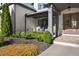Charming covered front porch featuring stone flooring and a seating area, complemented by lush landscaping at 4370 Freys Farm Nw Ln, Kennesaw, GA 30152