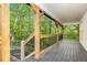 Covered back porch with a wood railing and supports overlooking trees at 4614 Riveredge Cv, Snellville, GA 30039