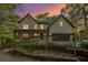 Charming two-story home with a welcoming front porch and well-maintained landscaping at sunset at 4614 Riveredge Cv, Snellville, GA 30039
