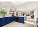 Inviting kitchen featuring blue cabinets, modern appliances, and open access to the living area at 4614 Riveredge Cv, Snellville, GA 30039