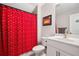 Bathroom featuring a shower with a red and black printed curtain and a white vanity at 503 Forest Ln, Canton, GA 30114
