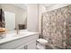 Well-lit bathroom featuring a white vanity, a decorative shower curtain, and a functional toilet at 503 Forest Ln, Canton, GA 30114