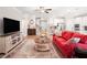 Bright living room with a red couch, detailed rug, and hardwood floors at 503 Forest Ln, Canton, GA 30114