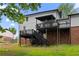View of the home's backyard with a large deck and stairs leading to the lawn at 6659 Manoleta Dr, Lithonia, GA 30038