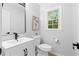 Clean bathroom features a modern sink, toilet, and a sunlit window at 6659 Manoleta Dr, Lithonia, GA 30038