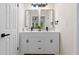 Modern bathroom with dual sink vanity, black hardware, and decorative mirror at 6659 Manoleta Dr, Lithonia, GA 30038