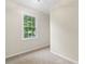 Compact bedroom featuring neutral carpet and a window offering natural light at 6659 Manoleta Dr, Lithonia, GA 30038