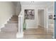 Bright foyer features staircase with carpet runner, wood flooring, and neutral paint at 6659 Manoleta Dr, Lithonia, GA 30038