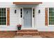 Charming front entrance with a stylish gray door, decorative shutters, and a welcoming brick step at 6659 Manoleta Dr, Lithonia, GA 30038