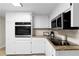Updated kitchen with white cabinets, stainless appliances, granite counters, and plank flooring at 6659 Manoleta Dr, Lithonia, GA 30038