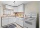 Compact kitchen with white cabinets, laminate countertops, and modern appliances at 6659 Manoleta Dr, Lithonia, GA 30038