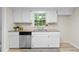 Updated kitchen with white cabinets, stainless appliances, granite counters, and plank flooring at 6659 Manoleta Dr, Lithonia, GA 30038