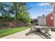 A peaceful backyard with a lush lawn, mature trees, and a stone patio with outdoor seating at 1555 Heritage Trl, Roswell, GA 30075