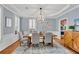 Stylish dining room with a coffered ceiling, chandelier, and wainscoting at 1555 Heritage Trl, Roswell, GA 30075