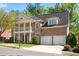 Charming brick home with a covered porch, balcony, two-car garage, and a well-maintained lawn at 1555 Heritage Trl, Roswell, GA 30075