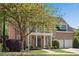 Attractive brick home with a columned porch, two-car garage, and mature shade trees at 1555 Heritage Trl, Roswell, GA 30075