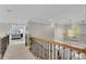 Upstairs hallway with wood and iron railing leading to the bedrooms and a view of the foyer at 1555 Heritage Trl, Roswell, GA 30075