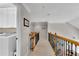 Bright hallway with wood and iron railing leads to the laundry room with white cabinets at 1555 Heritage Trl, Roswell, GA 30075