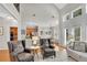 Open-concept living room with fireplace, tall windows, and easy access to the kitchen and dining area at 1555 Heritage Trl, Roswell, GA 30075