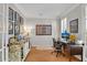 Well-lit home office with hardwood floors, built-ins, and natural light from shuttered windows at 1555 Heritage Trl, Roswell, GA 30075
