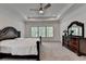 Large bedroom featuring a ceiling fan, tray ceilings, and coordinating furniture at 3180 Andover St, Cumming, GA 30028