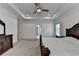 A bright primary bedroom featuring tray ceilings, a ceiling fan, and coordinating dark wood furniture at 3180 Andover St, Cumming, GA 30028