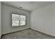 Bright bedroom featuring gray carpet, neutral walls, and a window providing natural light at 3180 Andover St, Cumming, GA 30028