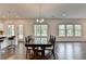Dining room with hardwood floors, a modern chandelier, and views of the large backyard at 3180 Andover St, Cumming, GA 30028