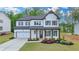 Inviting two-story home with a two-car garage, white painted brick, complemented by dark brown shutters and trim at 3180 Andover St, Cumming, GA 30028