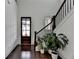 Bright foyer with a dark wood front door, hardwood floors, staircase, and neutral paint at 3180 Andover St, Cumming, GA 30028