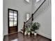 Bright foyer with a dark wood front door, hardwood floors, staircase, and neutral paint at 3180 Andover St, Cumming, GA 30028
