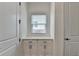 Hallway with a small window, white cabinets, and dark hardware at 3180 Andover St, Cumming, GA 30028