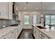 Kitchen island featuring stainless steel appliances, marble countertops, dark hardware and modern lighting at 3180 Andover St, Cumming, GA 30028