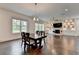 Open-concept living and dining area with hardwood floors and stone fireplace feature at 3180 Andover St, Cumming, GA 30028