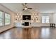 Living room boasting hardwood floors, a stone fireplace, custom built-ins, and large windows at 3180 Andover St, Cumming, GA 30028
