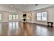 Spacious living room featuring hardwood floors, a stone fireplace, custom built-ins, and large windows at 3180 Andover St, Cumming, GA 30028