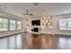 Bright, spacious living room with hardwood floors, many windows, and stone fireplace wall with TV at 3180 Andover St, Cumming, GA 30028