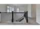 View of a light-filled staircase with dark wood railings and wrought iron spindles at 3180 Andover St, Cumming, GA 30028