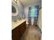 Bathroom featuring wood look floors, wood cabinets, white walls and accent curtains at 3876 Winners Ct, Marietta, GA 30062