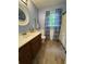 Bright bathroom featuring a wood vanity, white countertops, and wood flooring at 3876 Winners Ct, Marietta, GA 30062