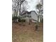 View of the two-story home featuring a covered porch and three car garage nestled among mature trees at 3876 Winners Ct, Marietta, GA 30062