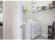 A practical laundry room with side-by-side washer and dryer and storage shelves at , Atlanta, GA 30316