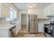 Bright kitchen features white cabinets, stainless steel appliances, and wood-look floors at 270 Hunt Ridge Dr, Stockbridge, GA 30281