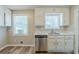 Well-lit kitchen with white cabinets, stainless steel dishwasher, and wood-look floors at 270 Hunt Ridge Dr, Stockbridge, GA 30281