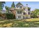 Two-story home boasts a large backyard with a patio, a deck, and mature trees at 5100 Sunset Maple Trl, Lilburn, GA 30047