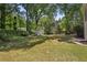 Spacious backyard with mature trees and a well-maintained lawn, perfect for outdoor enjoyment and recreation at 5100 Sunset Maple Trl, Lilburn, GA 30047
