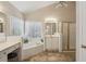 Bright bathroom featuring a corner soaking tub with tiled surround and window, plus a glass-enclosed shower at 5100 Sunset Maple Trl, Lilburn, GA 30047
