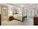 Traditional primary bedroom with a canopy bed, windows, and neutral carpet at 5100 Sunset Maple Trl, Lilburn, GA 30047